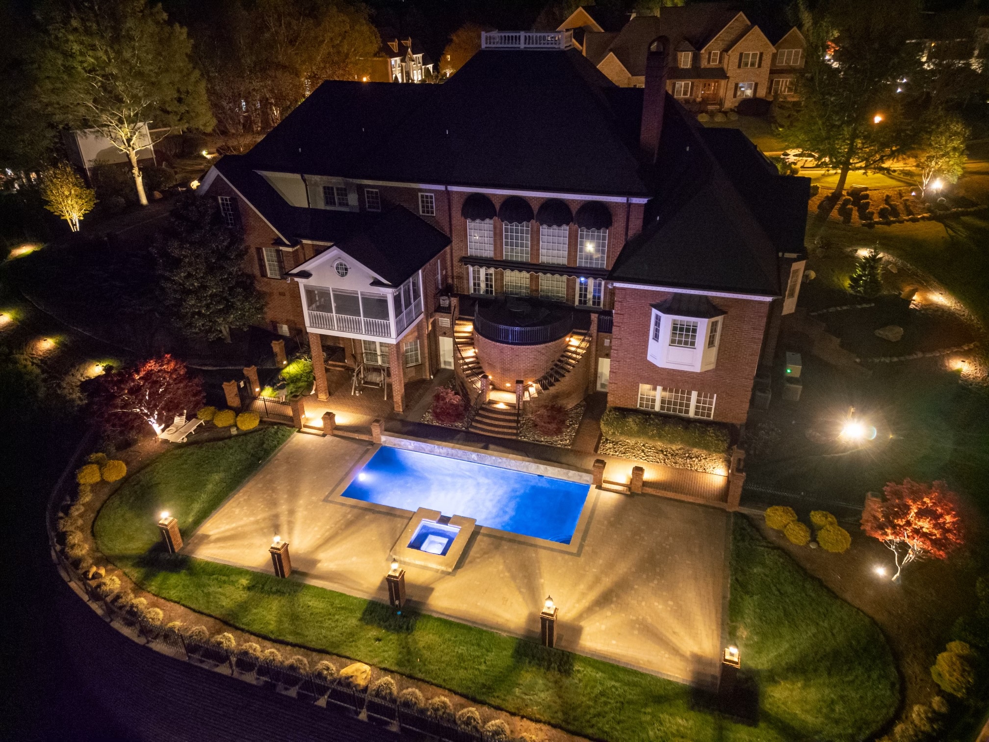 night time picture of house and pool patio with outdoor lighting